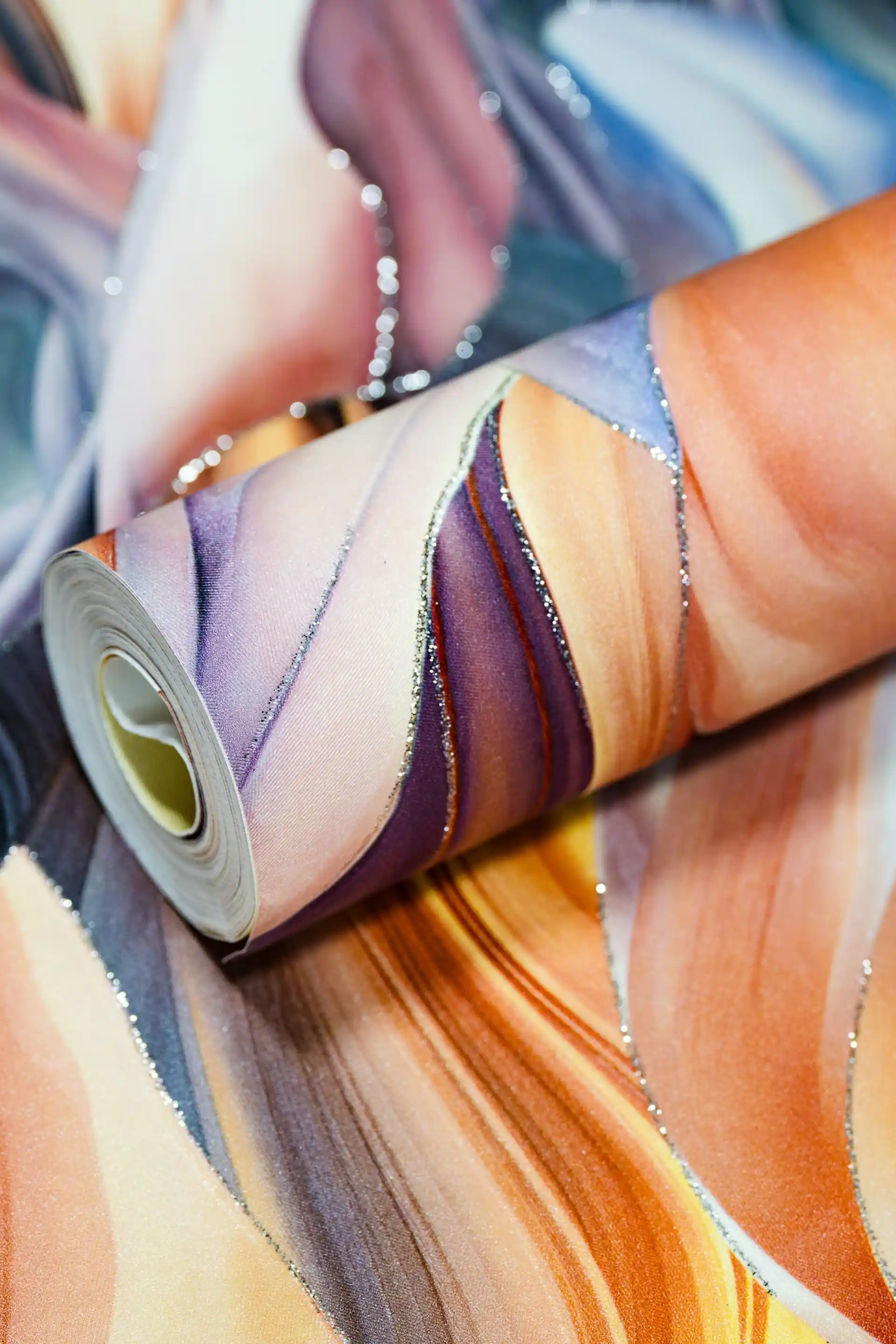 Rolled rainbow feather pattern wallpaper in warm peach, purple, and blue tones with silver glitter edges
