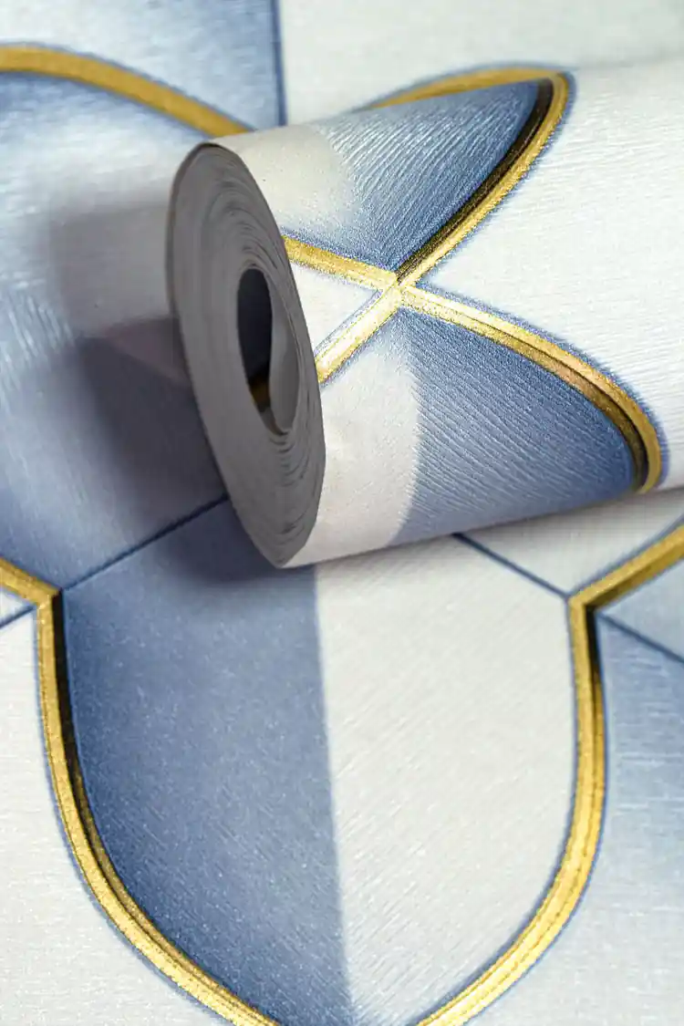 Rolled wallpaper showing blue and grey geometric hexagon pattern with metallic gold detailing
