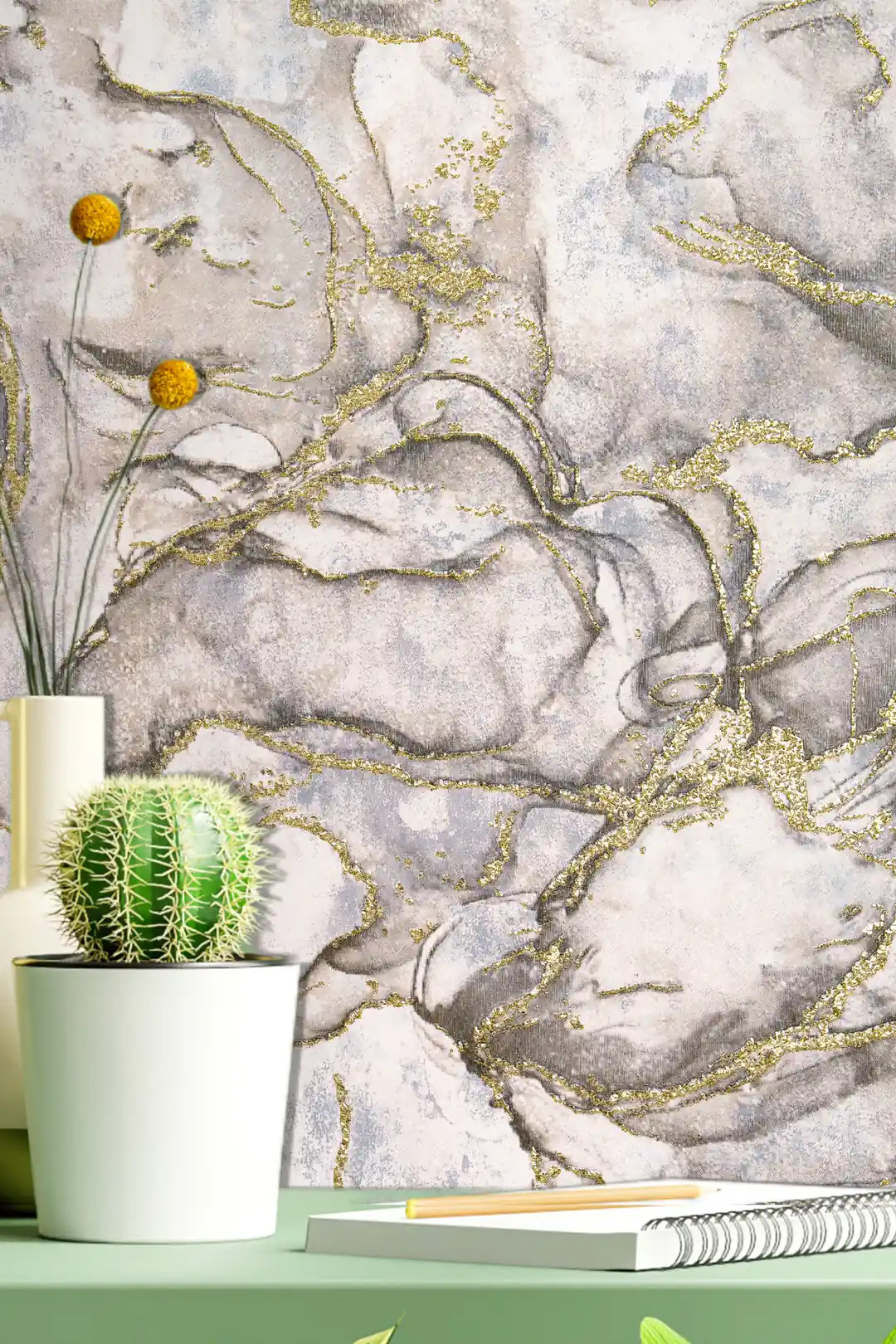 Styled vignette of grey marble wallpaper with gold veins behind a cactus and desk accessories