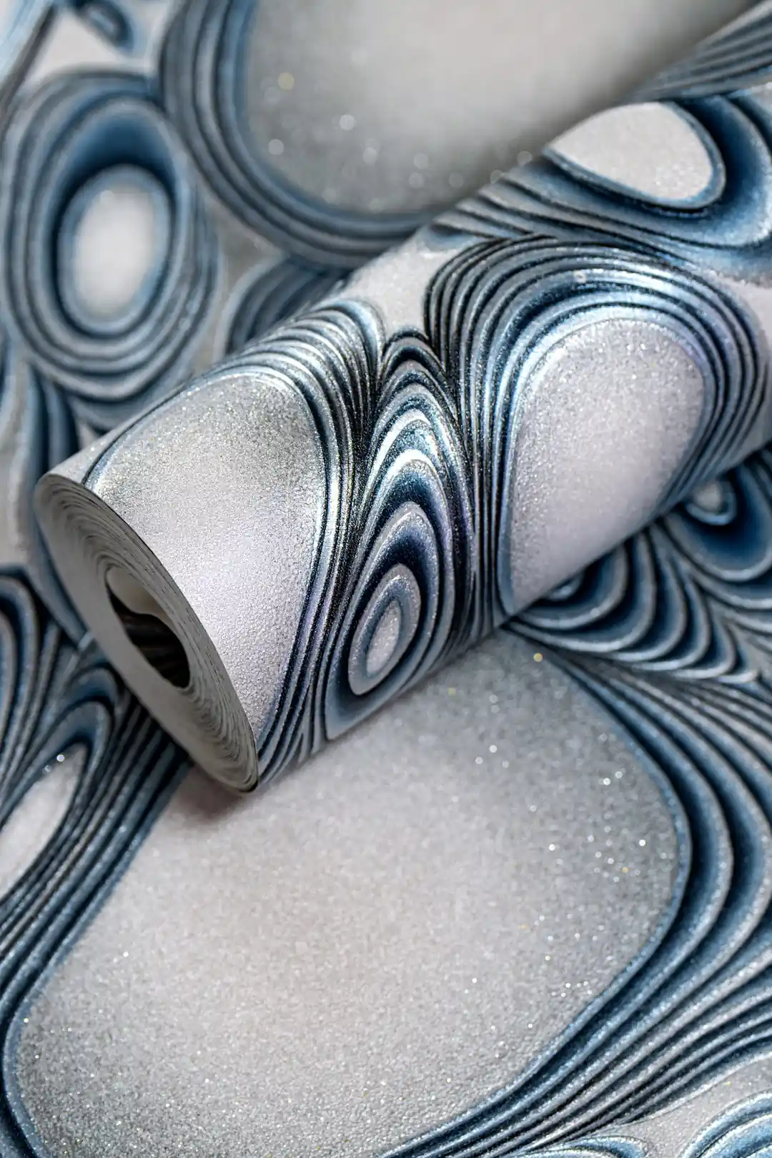 Rolled wallpaper with abstract metallic blue molten steel curves and silver glitter finish