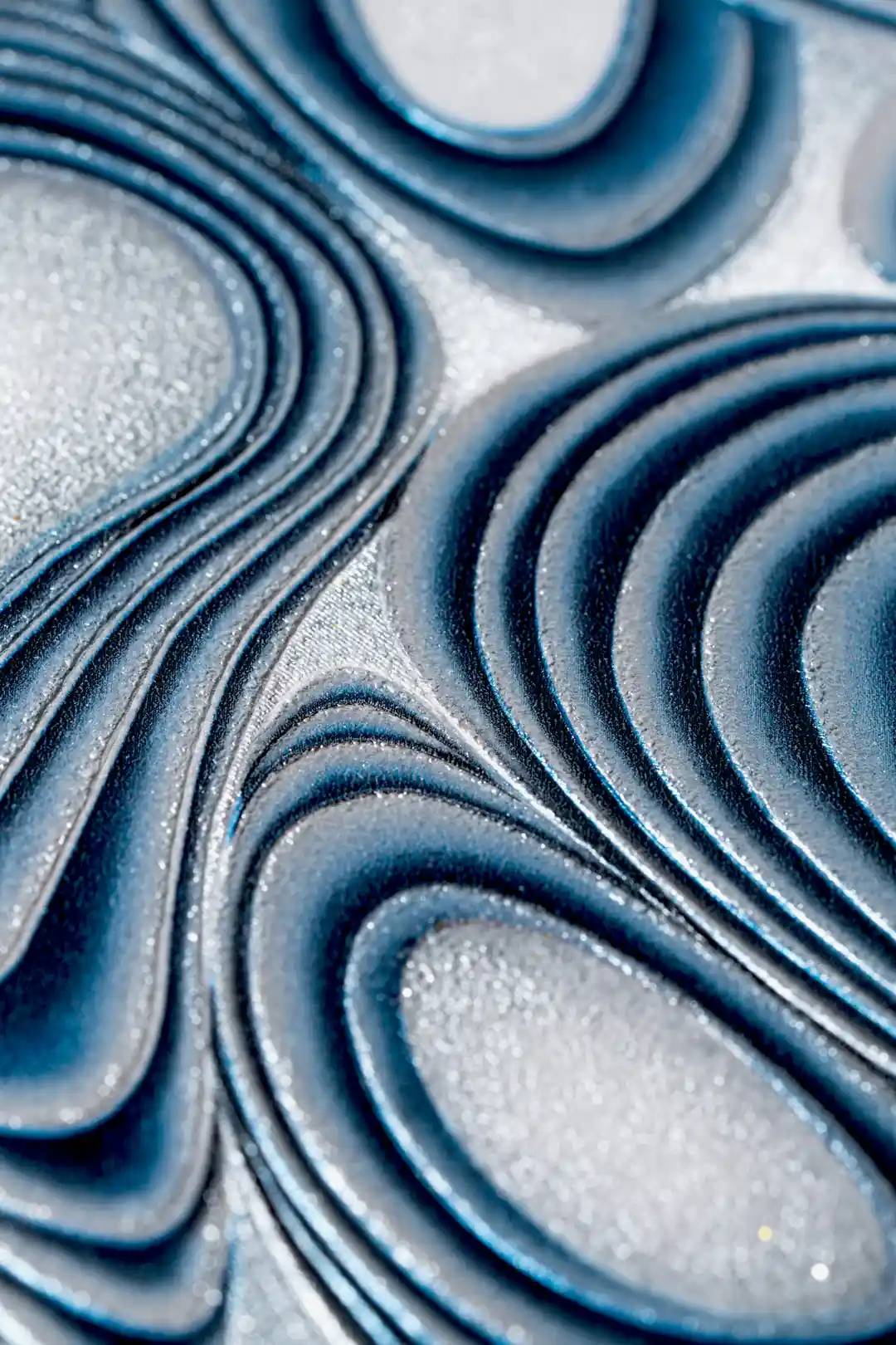 Extreme macro of deep blue swirling ridges and sparkling silver glitter texture detail