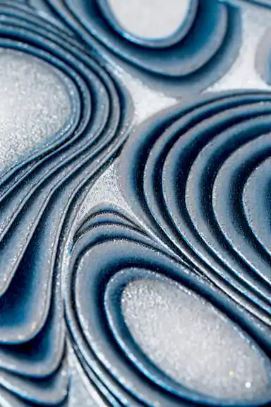 Extreme macro of deep blue swirling ridges and sparkling silver glitter texture detail