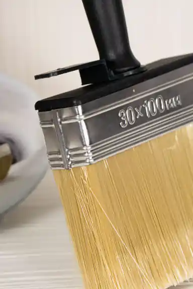 Close-up of the 30x100mm metal ferrule and bristle detail on the wallpaper application brush