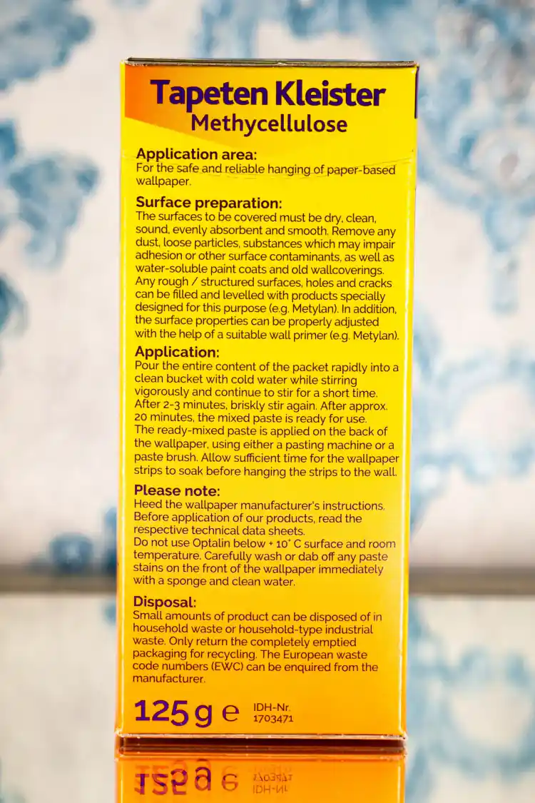 Side panel of Tapeten Kleister wallpaper glue box with application instructions, surface preparation steps, and 125g weight