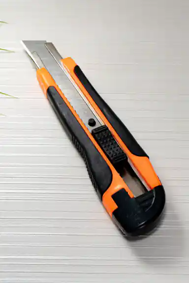 Flat overhead view of the orange and black utility knife with extended snap-off blade