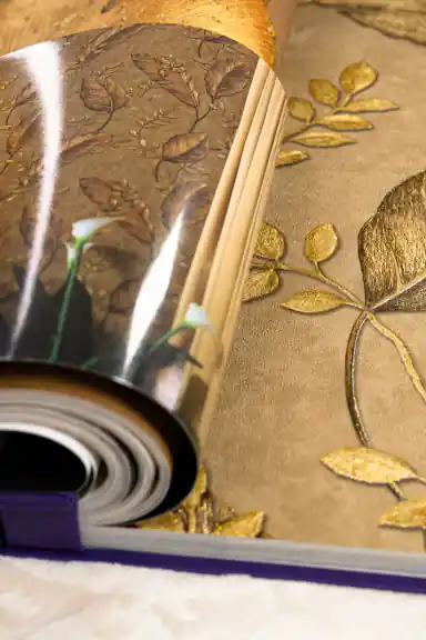 Pages of WOTO 1 catalogue displaying golden leaf and botanical wallpaper patterns in warm tones