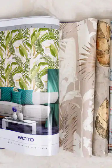 Open WOTO 1 book showing tropical green leaf and blush palm wallpaper designs with room scenes